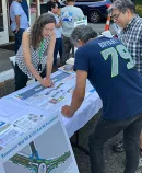 Community members review maps and plans at an outdoor table